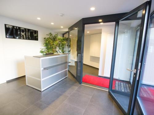 een kamer met een witte dressoir met een plant erin bij Hotel Gregory in Zürich