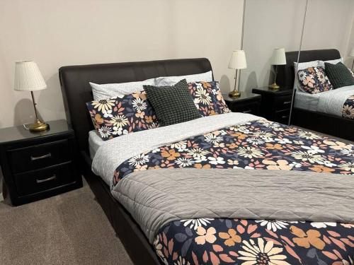 a bedroom with a bed and two night stands with lamps at Cityscape Lovely 1BR Apt & Parking @CBD in Canberra