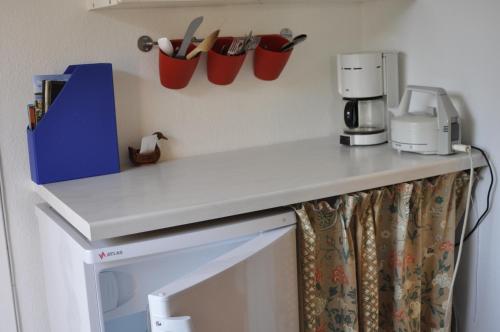 um balcão de cozinha com comodidades para preparar café e chávenas na parede em Guesthouse Højland em Ry
