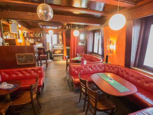 a restaurant with red leather couches and tables at Hotel Gregory in Zürich