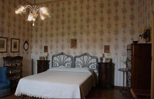 a bedroom with a bed and a chandelier at Appartamento Villa Romano in Piano di Sorrento