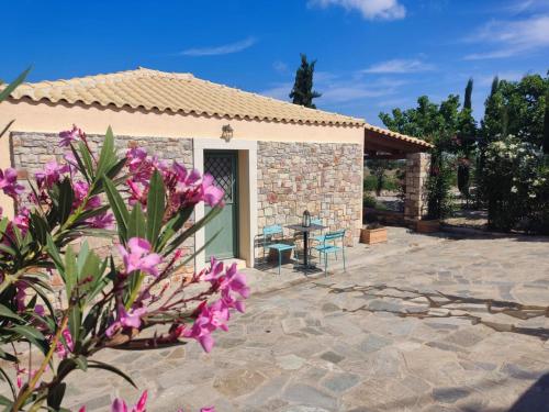 a house with a patio with purple flowers at DESPOSIA Karavas in Kythira