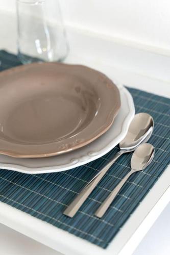 a plate and two spoons on a drying rack at Dora Apartment in Áyios Andónios