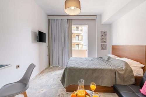 a bedroom with a bed and a table with wine glasses at Dora Apartment in Áyios Andónios
