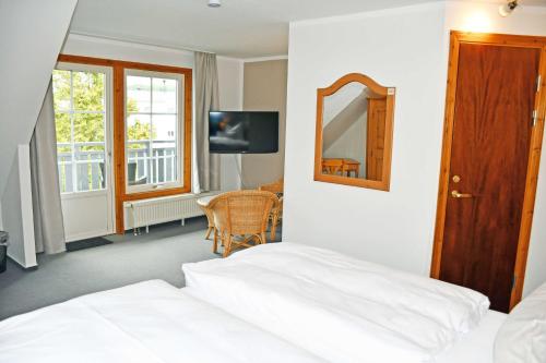 a bedroom with a bed and a mirror and a table at Hotel Inselglück in Lohme