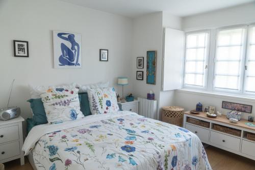 a bedroom with a bed and two windows at CASTEL SAINT CLAIR in Deauville