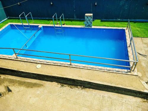 a large blue swimming pool with metal rails at CASILINA GUEST HOME in Limbe
