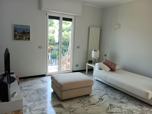 a white living room with a bed and a chair at Casa Oliveta in Rapallo