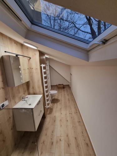 La salle de bains est pourvue d'un lavabo et d'une lucarne. dans l'établissement Domek na uboczu 3 pokoje 2 łazienki i taras, à Cracovie