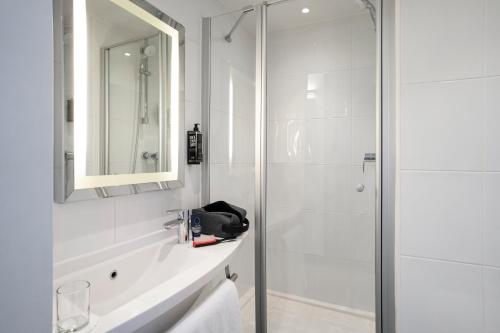 a white bathroom with a shower and a sink at ibis Edinburgh Centre Royal Mile &ndash; Hunter Square in Edinburgh