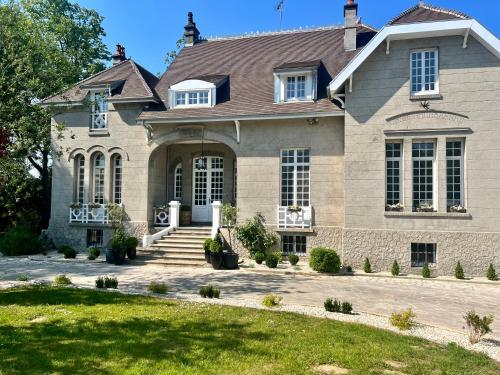 a large stone house with a roof at Manoir Les Feuillantines Piscine & Spa in Isques
