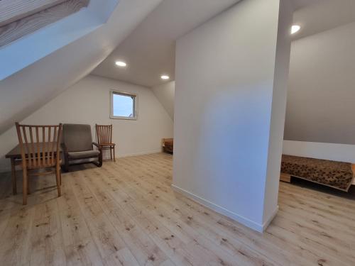 - un salon mansardé avec une table et des chaises dans l'établissement Domek na uboczu 3 pokoje 2 łazienki i taras, à Cracovie