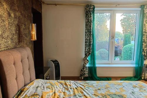 a bedroom with a bed and a window with green curtains at Villa Sonnen-Blick in Aachen