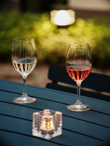 two glasses of wine sitting on a table at Holiday Inn Gdansk - City Centre by IHG in Gdańsk