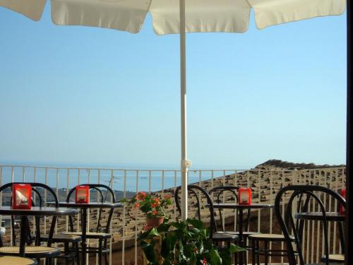 a row of tables and chairs with a view of the ocean at FORESTERIA DEL TEATRO in Agrigento