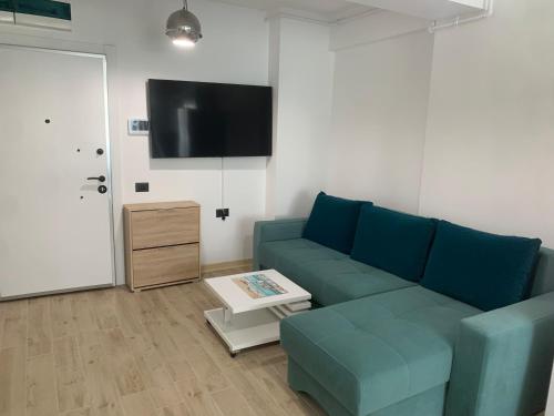 a living room with a blue couch and a tv at David & Andrei Infinity in Mamaia Nord
