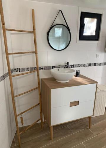 une salle de bain avec un lavabo et un miroir dans l'établissement Entre Mer et Montagne, à Sartène