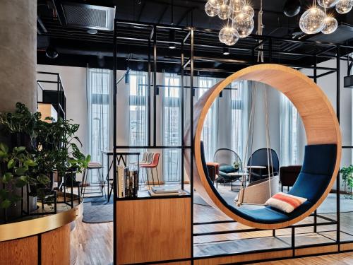 a room with a circular mirror and a chair at Holiday Inn Gdansk - City Centre, an IHG Hotel in Gdańsk