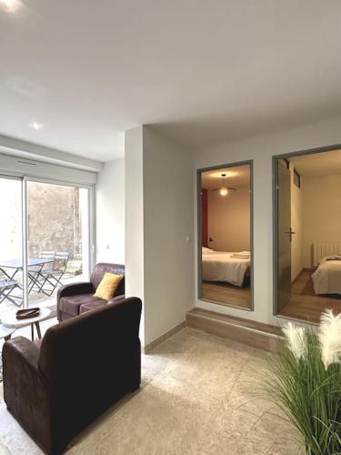 - un salon avec un canapé et une chambre dans l'établissement Appartement centre ville - PARKING PRIVE - WIFI, à Nîmes