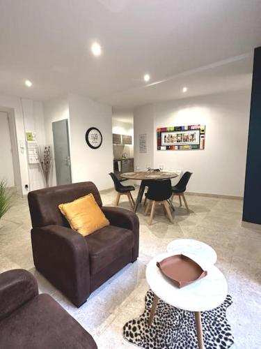 un salon avec un canapé et une table dans l'établissement Appartement centre ville - PARKING PRIVE - WIFI, à Nîmes