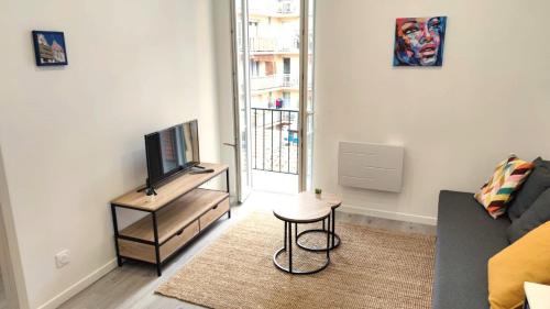 un salon avec un canapé et une télévision dans l'établissement Republique centre 31, à Nice