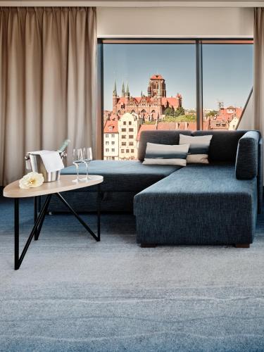 a living room with a couch and a table at Holiday Inn Gdansk - City Centre by IHG in Gdańsk