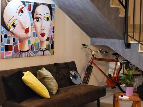 - un salon avec un canapé et une peinture de deux femmes dans l'établissement INDUSTRY HOME, à Catane