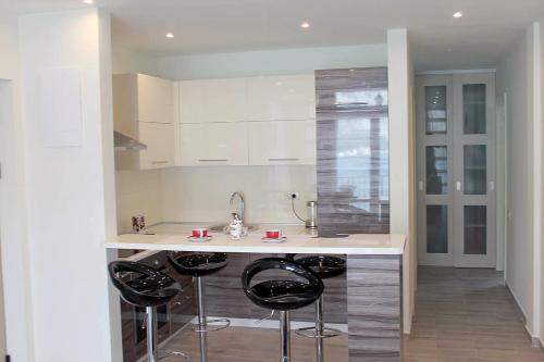 a kitchen with two bar stools and a counter at Apartment Felicita Prcanj Boko Kotor in Kotor