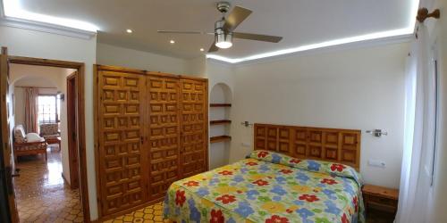 1 dormitorio con cama y puertas de madera en Alsol El Chaparral, en Playa del Inglés