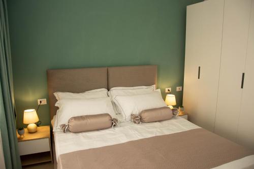 Un dormitorio con una cama con dos bolsas. en Wave Beachfront Apartments en Durrës