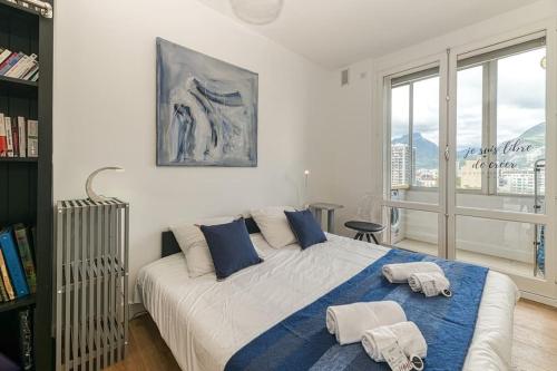 une chambre avec un grand lit avec deux serviettes dessus dans l'établissement 117 liberation GRENOBLE, à Grenoble