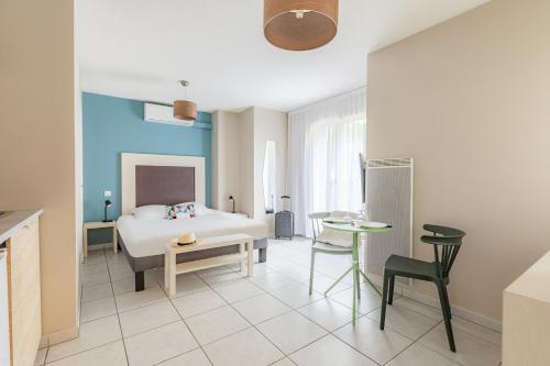 una camera da letto con un letto, un tavolo e delle sedie di Appart'City Classic Bordeaux Aéroport St Jean D'Illac a Saint-Jean-d'Illac
