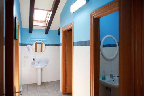 uma casa de banho com paredes azuis, um lavatório e um espelho. em Amaiurko Aterpea em Maya del Baztán