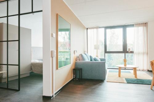 a living room with a couch and a mirror at The Forest apartments by Daniel&Jacob's in Kongens Lyngby