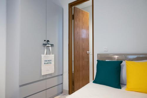 a bedroom with a bed with yellow and blue pillows at TwoSpaces Living at Zena Mozia in Tegal