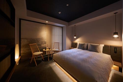 a bedroom with a large bed and a table and chairs at Hotel Resol Trinity Osaka in Osaka
