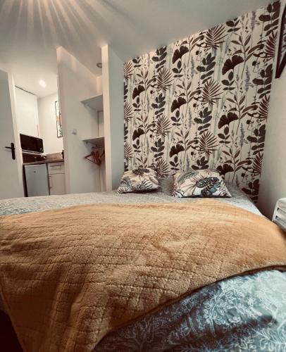 - une chambre avec un grand lit et une tête de lit à motifs dans l'établissement Rouen Saint Nicaise, à Rouen