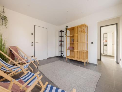 sala de estar con 2 sillas y estante para libros en Bienenhaus, en Monschau