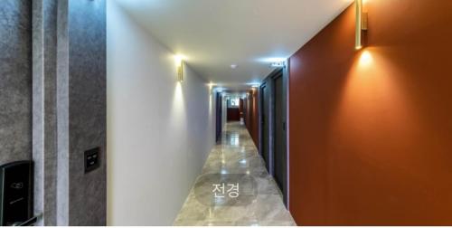 a hallway with an orange wall and a long corridor at Hotel Sono in Incheon