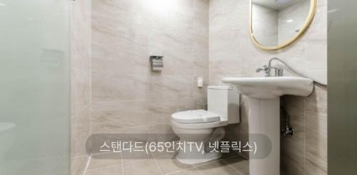 een badkamer met een toilet, een wastafel en een spiegel bij Hotel Sono in Incheon