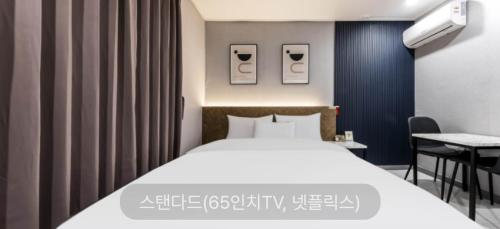 a bedroom with a white bed and a desk at Hotel Sono in Incheon