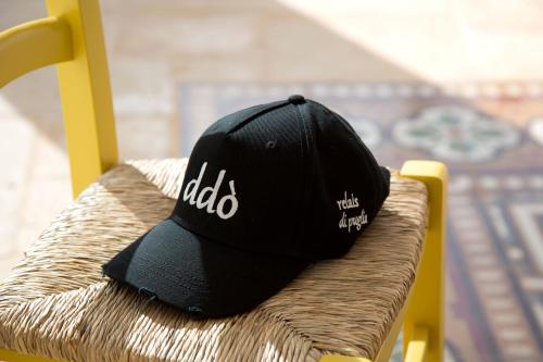 a black baseball cap sitting on a chair at Ddò Relais di Puglia in Ostuni