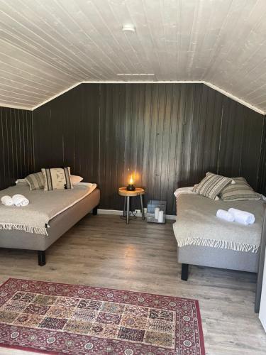 a bedroom with two beds and a table with a candle at Raet Camping in Færvik