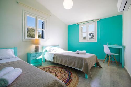 a bedroom with two beds and a desk and two windows at Villa Filokalia With Exceptional View - Happy Rentals in Kastro Kyllini