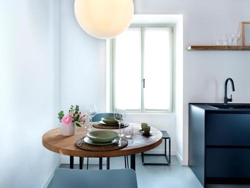 a kitchen with a wooden table and a sink at SG9 CITY APARTMENTS in Brescia
