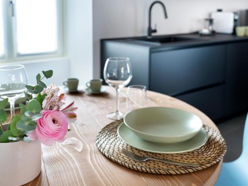 a wooden table with a plate and wine glasses at SG9 CITY APARTMENTS in Brescia