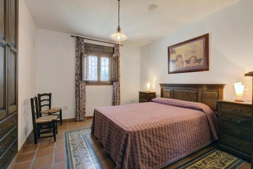 a bedroom with a bed and a dresser and a window at Casa Jimena 2 personas in Jimena de la Frontera