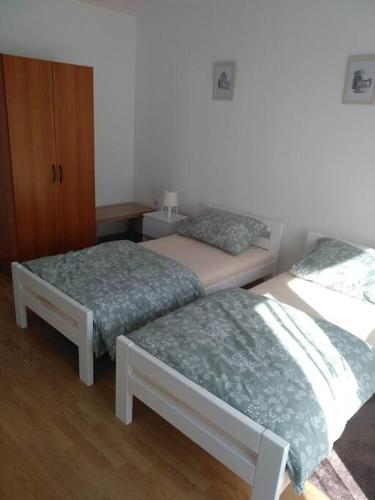 a bedroom with two beds and a dresser at Apartman Vidaković in Bilje