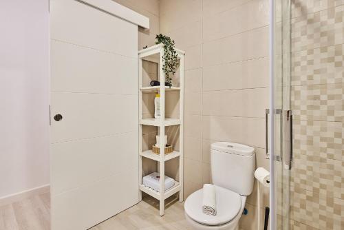 a white bathroom with a toilet and a shower at Redo Home in Cádiz