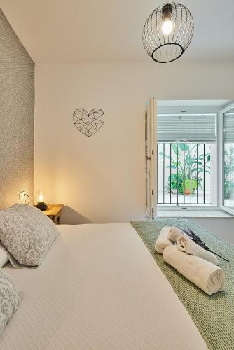 a bedroom with a large bed and a window at Redo Home El Pópulo in Cádiz